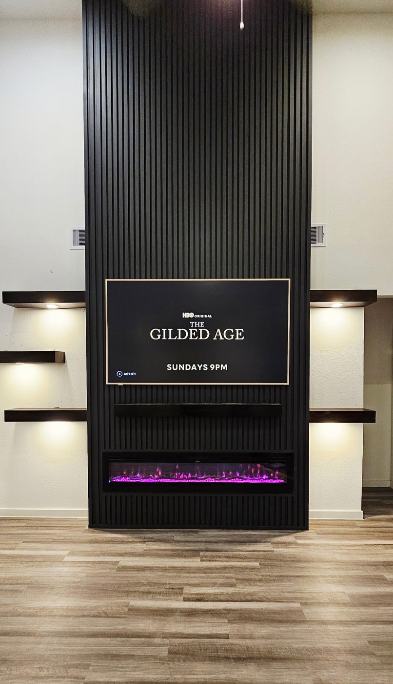 Masters HD TV installation on a custom slat-wall feature with bias lighting and electric fireplace.